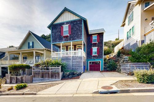 a house with a red door on a street at Knot a Care in Lincoln City