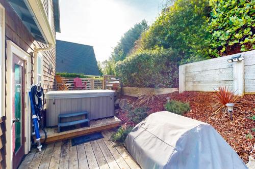 a garden with a hot tub on a wooden deck at Knot a Care in Lincoln City