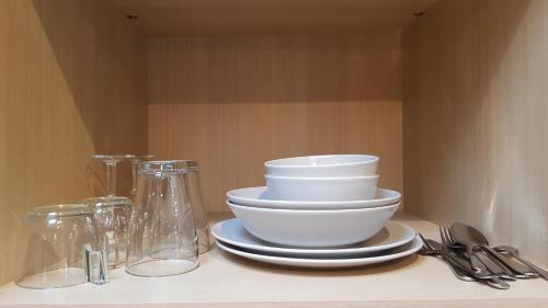 a pile of bowls and plates sitting on a shelf at Suite de charme avec terrasse, spa extérieur et petit piscine in Lédenon