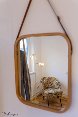 a mirror reflecting a chair and a lamp in a room at Ferienhaus Honey Bee in Billingsbach