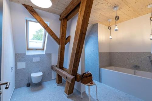 a bathroom with a tub and a toilet and a sink at Landurlaub mit neugierigen Blicken in den Pferdestall, eingezäuntem Garten, Kamin und Sauna in Rot am See