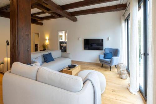 a living room with a white couch and blue chairs at Ferienhaus Gersmühle in Satteldorf