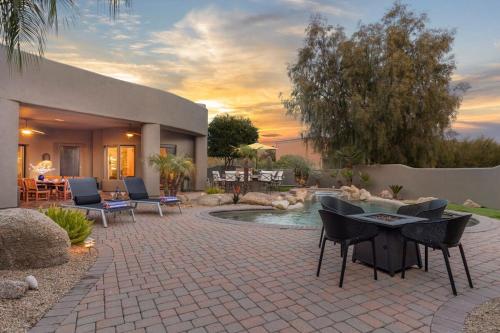 a patio with chairs and a pool in a backyard at Dale in Scottsdale