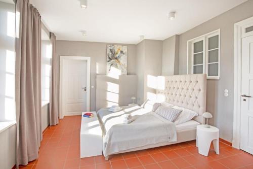 a bedroom with a white bed in a room with windows at Ferienhaus Forsthaus Stolpe in Stolpe