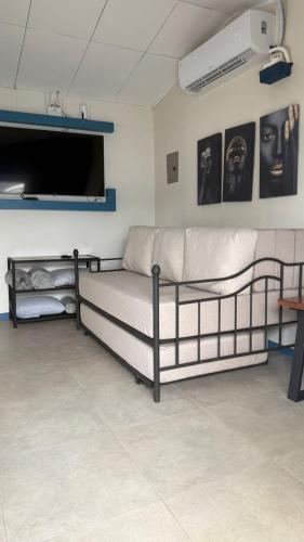 a room with two beds and a flat screen tv at La Casa de Papi. in Parrita