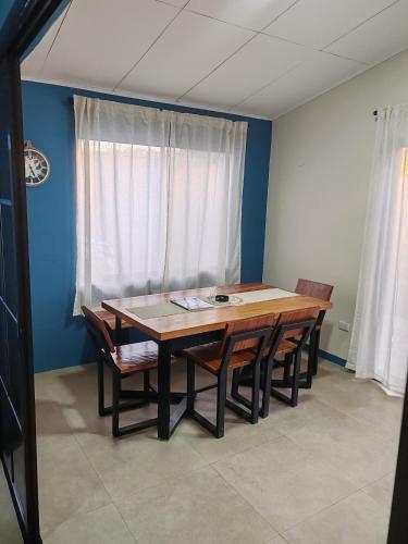 a dining room with a wooden table and chairs at La Casa de Papi. in Parrita