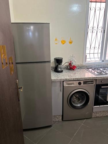 a kitchen with a refrigerator and a washing machine at Le nid zen in Marrakech