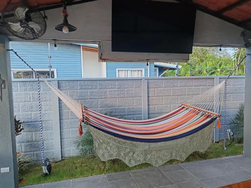 a hammock hanging in a backyard with a tv at La Casa de Papi. in Parrita