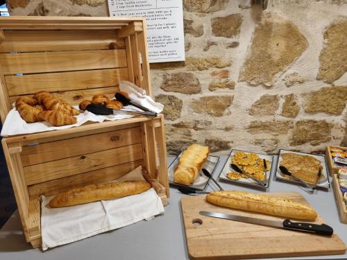 a table topped with bread and pastries and a knife at Hotel Le Bourgogne in Cuiseaux
