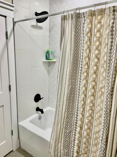 a bathroom with a shower curtain and a sink at NEW Stunning Views & Lake Access Villa in Granbury