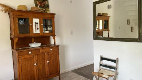 a wooden cabinet in a room with a mirror at Rincón del Río in San Antonio de Areco