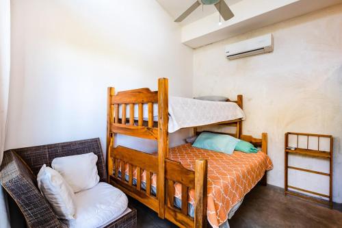 a bedroom with a bunk bed and a chair at Hammock House Your Private Oasis Near Tamarindo in Villarreal