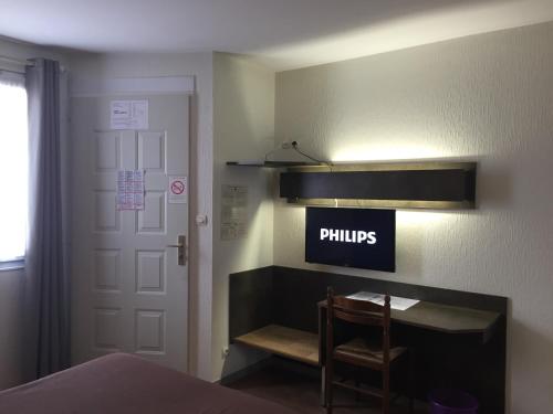 a bedroom with a sign that says philips on the wall at Hotel Marjolaine in Roullet