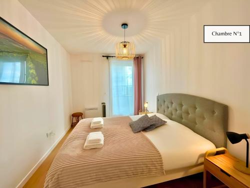 a bedroom with a large bed with two towels on it at L'Éclat Champenois - Terrasse-Gare-Arena in Reims