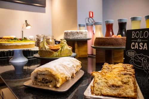 a table with different types of cakes and pies at Hotel Euro Suite São Jose do Rio Preto by Nacional Inn in Sao Jose do Rio Preto