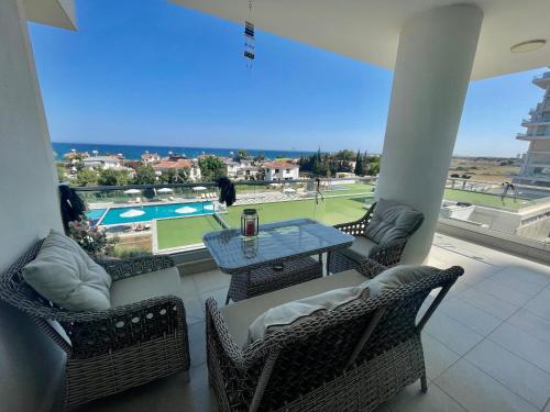a patio with a table and chairs and a tennis court at Sea Breeze Suites by the Coast in Iskele