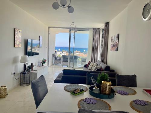 a living room with a couch and a table at Sea Breeze Suite by the Sea in Vokolidha