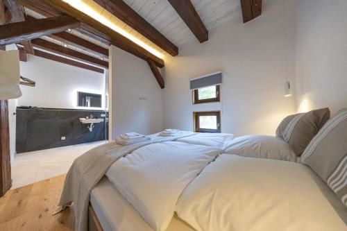 a bedroom with a large bed with white sheets at Ferienhaus Gersmühle in Satteldorf