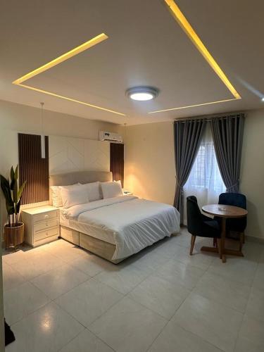 Un dormitorio con una cama, un escritorio y una mesa. en Whitelanesresidence, en Ankuru