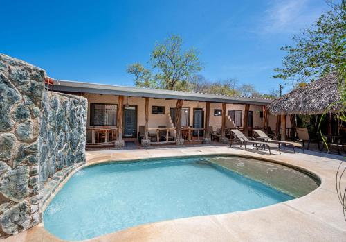 a swimming pool in front of a house at BP surf hotel in Refundores