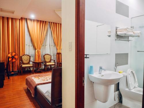 a bathroom with a bed and a sink and a sink at Huỳnh Gia Bảo Hotel in Bao Loc