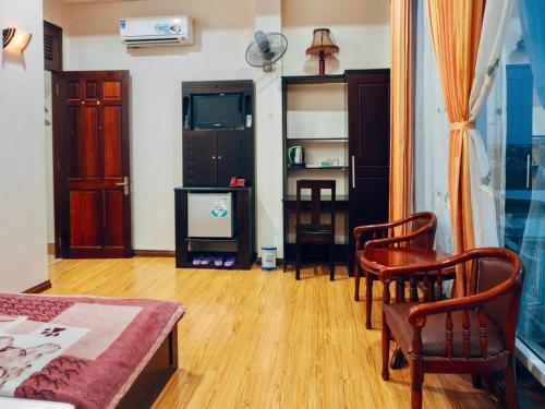 a living room with a couch and chairs and a tv at Huỳnh Gia Bảo Hotel in Bao Loc