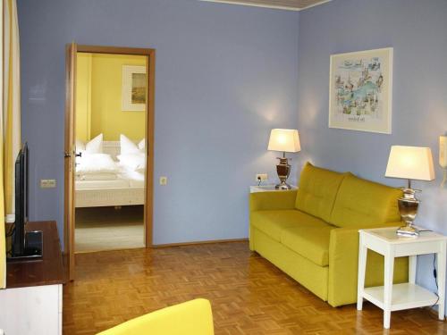 a living room with a yellow couch and a bedroom at Apartment in Meersburg by Lake Constance in Meersburg