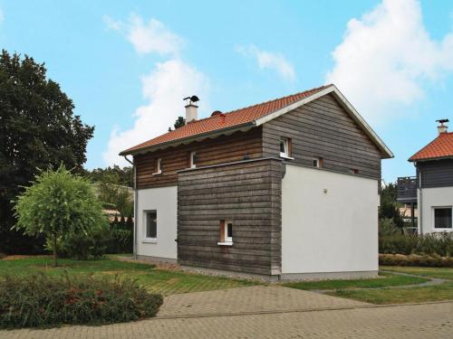 a small house with a white garage at Ferienhaus An de Linn, Nakenstorf in Nakensdorf