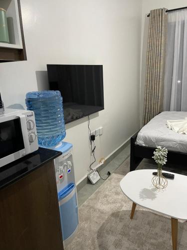 a small living room with a microwave and a table at Comfort and charm in Nairobi