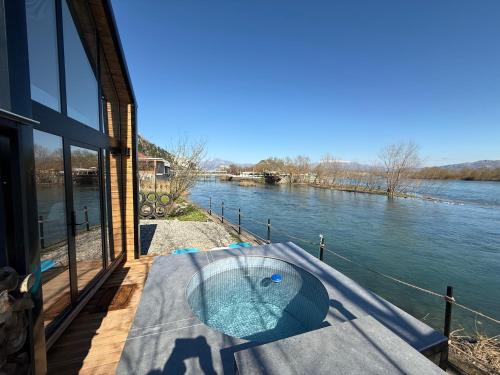 a swimming pool on a deck next to a river at 446 Tiny House Zues in Shkodër