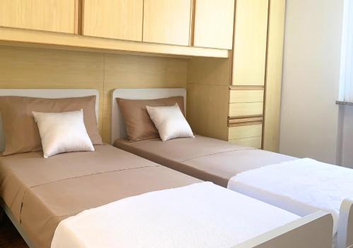 two beds sitting next to each other in a room at Wifi & Free Park BGY Airport 20 min in Zogno