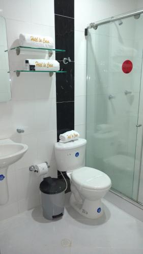 a white bathroom with a toilet and a shower at Hotel La Casa N. 3 in Montería