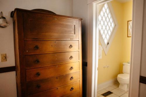 a bathroom with a wooden dresser and a toilet at Friendly City Inn B&B in Harrisonburg