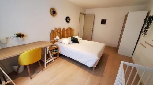 - une chambre avec un lit et un bureau avec une chaise jaune dans l'établissement Appartement T3 au Centre ville de Pau, à Pau