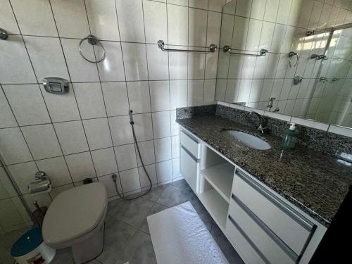 ein Badezimmer mit Toilette, Waschbecken und Spiegel in der Unterkunft Casa Frente Mar na Avenida Beira Mar 3 Itapoa in Itapoa