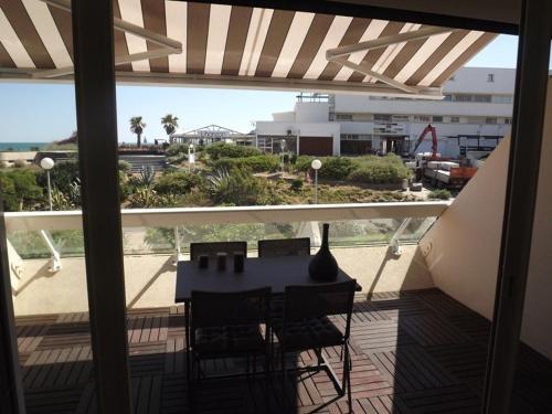 un balcon avec une table et des chaises sur une terrasse dans l'établissement Studio Graphik - Héliopolis C 74 - Luxe - 2 personnes, au Cap d'Agde