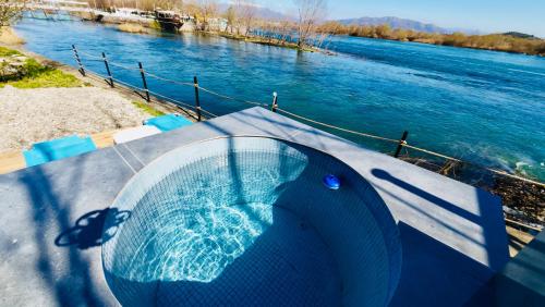 a hot tub sitting on the side of a river at 446 Tiny House Zues in Shkodër