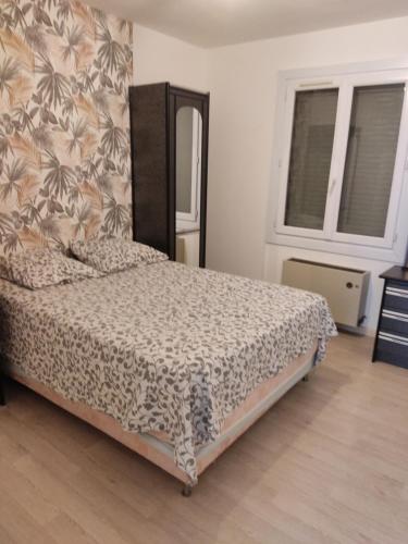 a bedroom with a bed with a patterned blanket at Maison de village in Alignan-du-Vent