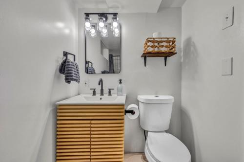 a bathroom with a sink and a toilet and a mirror at NEW! Modern Retreat Near CLE-Game Room-Renovated in Berea