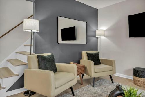 a living room with two chairs and a mirror at NEW! Modern Retreat Near CLE-Game Room-Renovated in Berea