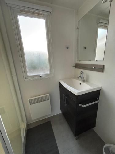 une salle de bain avec un lavabo et une fenêtre dans l'établissement Varéa Mobil'home, à Fréjus
