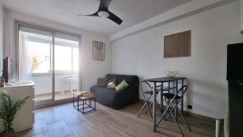 un salon avec un canapé et une table dans l'établissement Appartement Mer T2 Grau d 'Agde, au Grau-dʼAgde