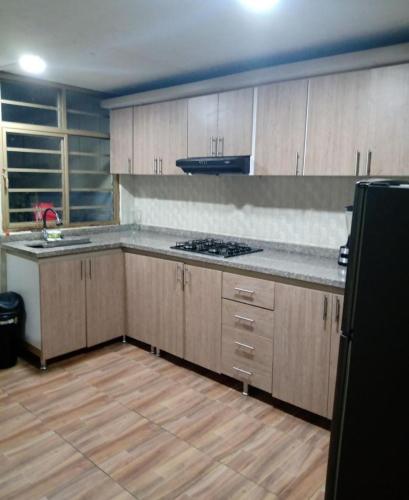 eine Küche mit Holzschränken und einer Arbeitsplatte in der Unterkunft habitación doble con parqueadero in Armenia