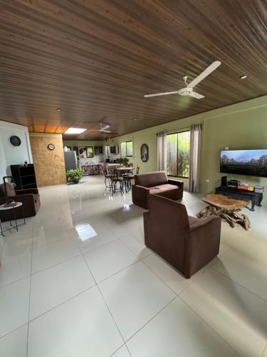 una gran sala de estar con sofás y techo. en Casa Pelicano, en Uvita