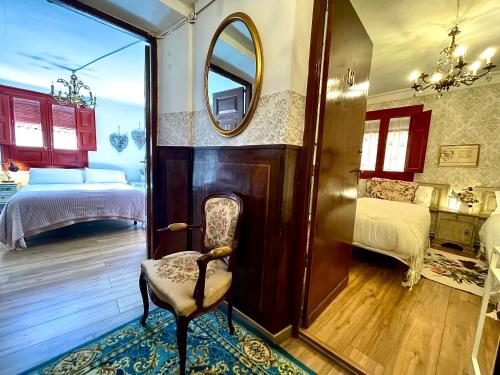 a room with a chair and a mirror and a bedroom at Riojania Heredad in Santa Eulalia Bajera