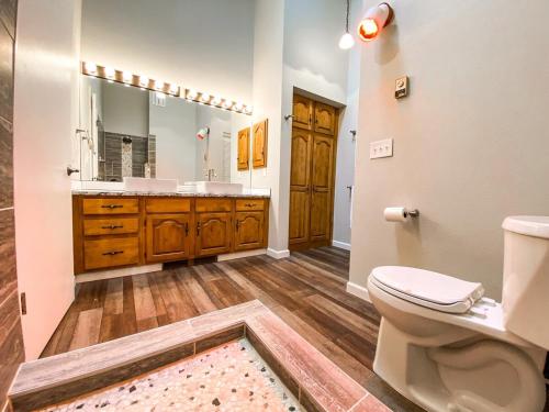 a bathroom with a toilet and a sink and a mirror at New Remodel in upscale neighborhood in Colorado Springs