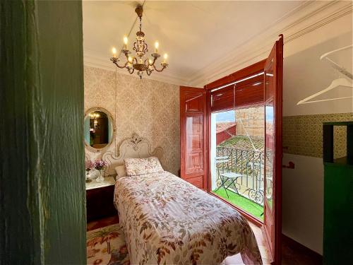a bedroom with a bed and a window and a chandelier at Riojania Heredad in Santa Eulalia Bajera