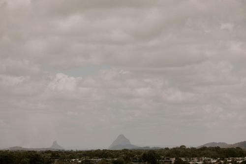 a kite flying in the sky over a city at Sand Dunes at Bok Beach in Kawana Waters