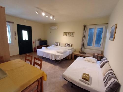 a room with two beds and a table and chairs at Ktima Pyroessa Apartments - Yellow Apartment in Thános
