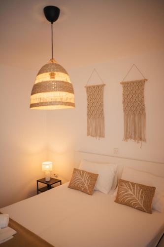 a bedroom with a white bed and a hanging lamp at Guesthouse Tamara in Lovište